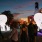 a group of people walking on a street with a large white balloon