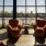 a bright room with cozy chairs and large windows